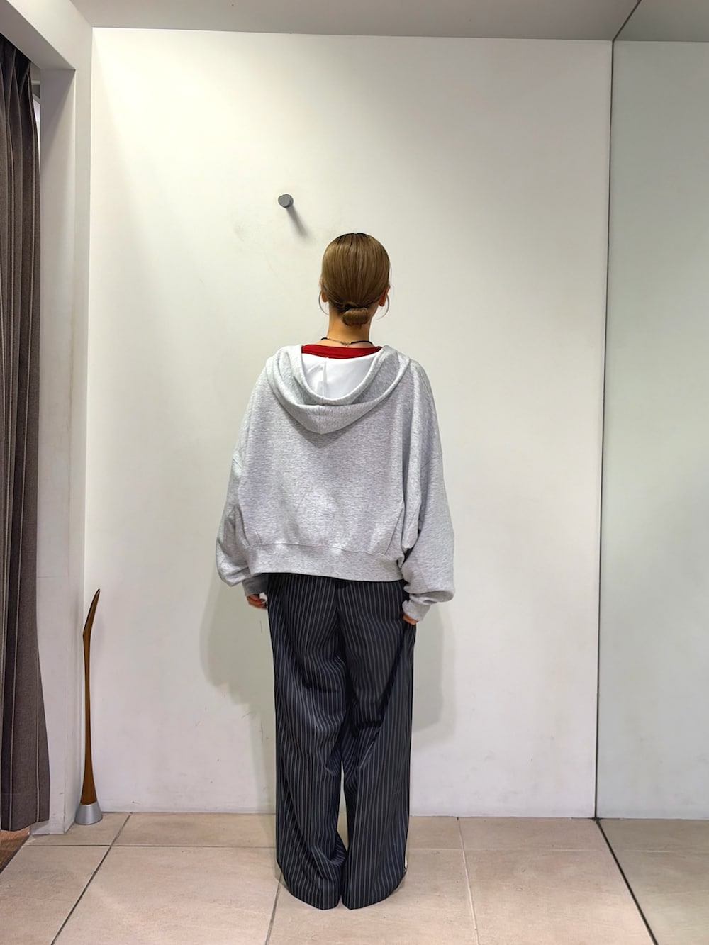 レッド系のニット/セーター、グレー系のパーカー、グレー系のその他パンツを着用したレディースの秋コーディネートの2枚目の写真