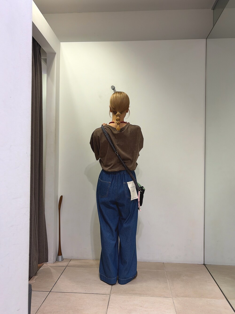 ブラウン系のTシャツ/カットソー、ブラック系のショルダーバッグ、ブルー系のデニムパンツを着用したレディースの夏コーディネートの2枚目の写真