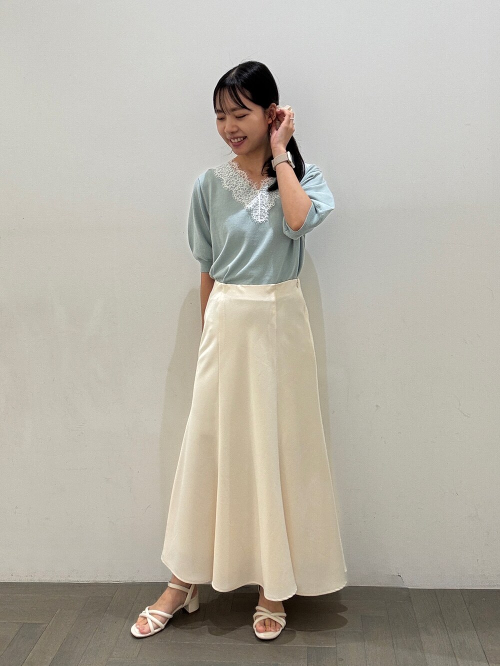 ブルー系のニット/セーター、ホワイト系のスカート、グレー系のトートバッグを着用したレディースの夏コーディネートの3枚目の写真