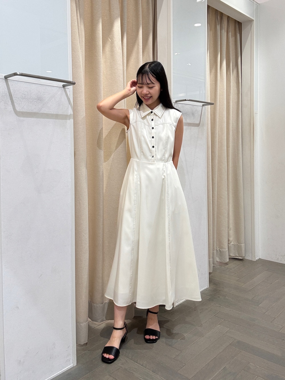 ホワイト系のワンピース、ホワイト系のトートバッグ、ブラック系のサンダルを着用したレディースの夏コーディネートの4枚目の写真