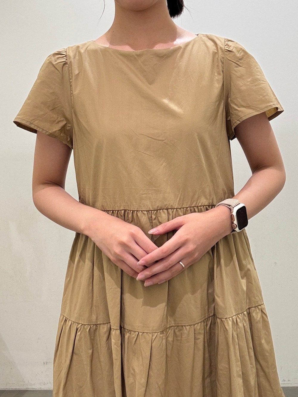 ベージュ系のワンピース、ホワイト系のボストンバッグ、ブラック系のサンダルを着用したレディースの夏コーディネートの5枚目の写真