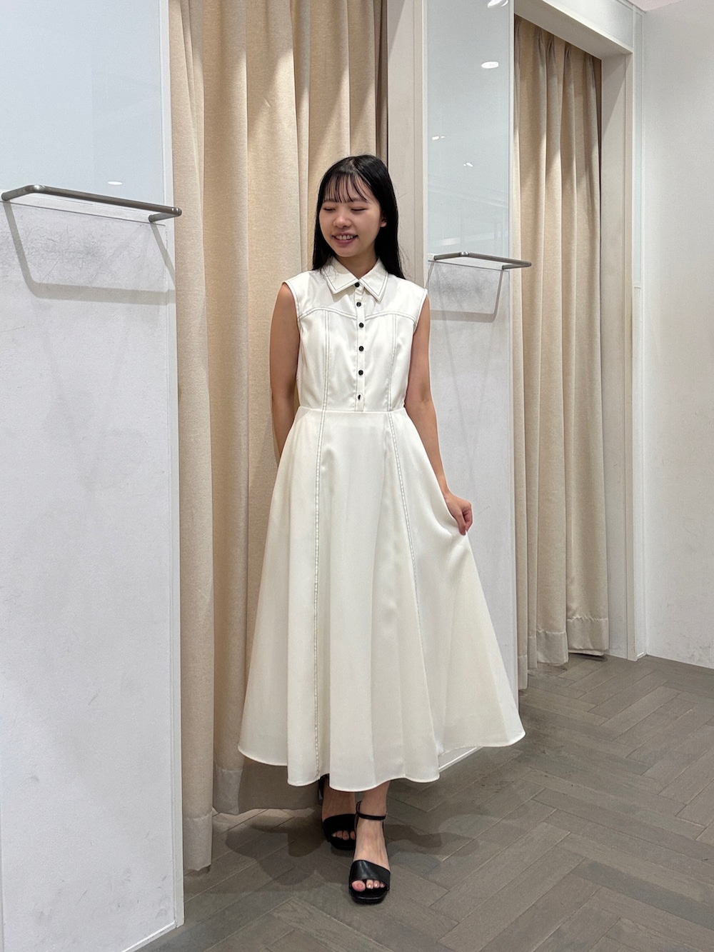 ホワイト系のワンピース、ホワイト系のトートバッグ、ブラック系のサンダルを着用したレディースの夏コーディネートの3枚目の写真
