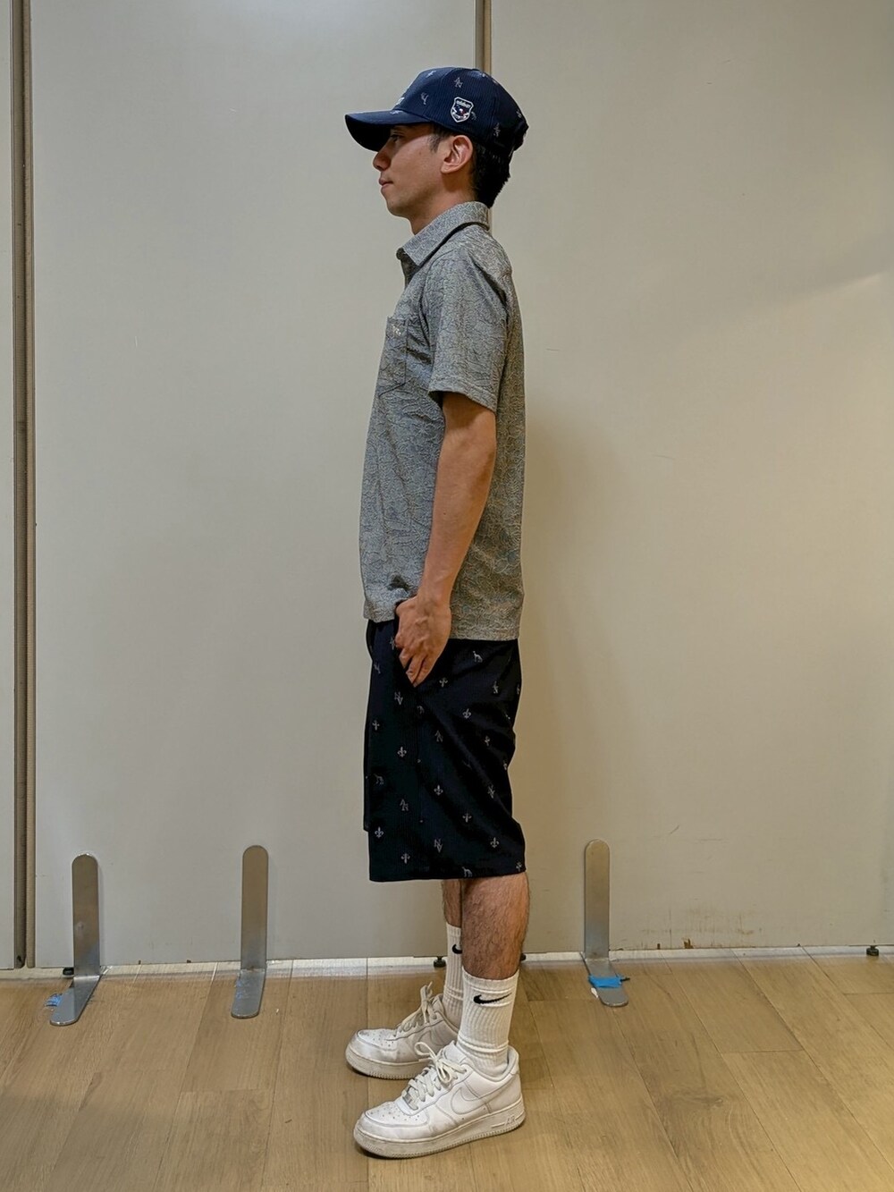 ブラック系のポロシャツ、ブルー系のその他パンツ、ブルー系のキャップを着用したメンズの夏コーディネートの2枚目の写真