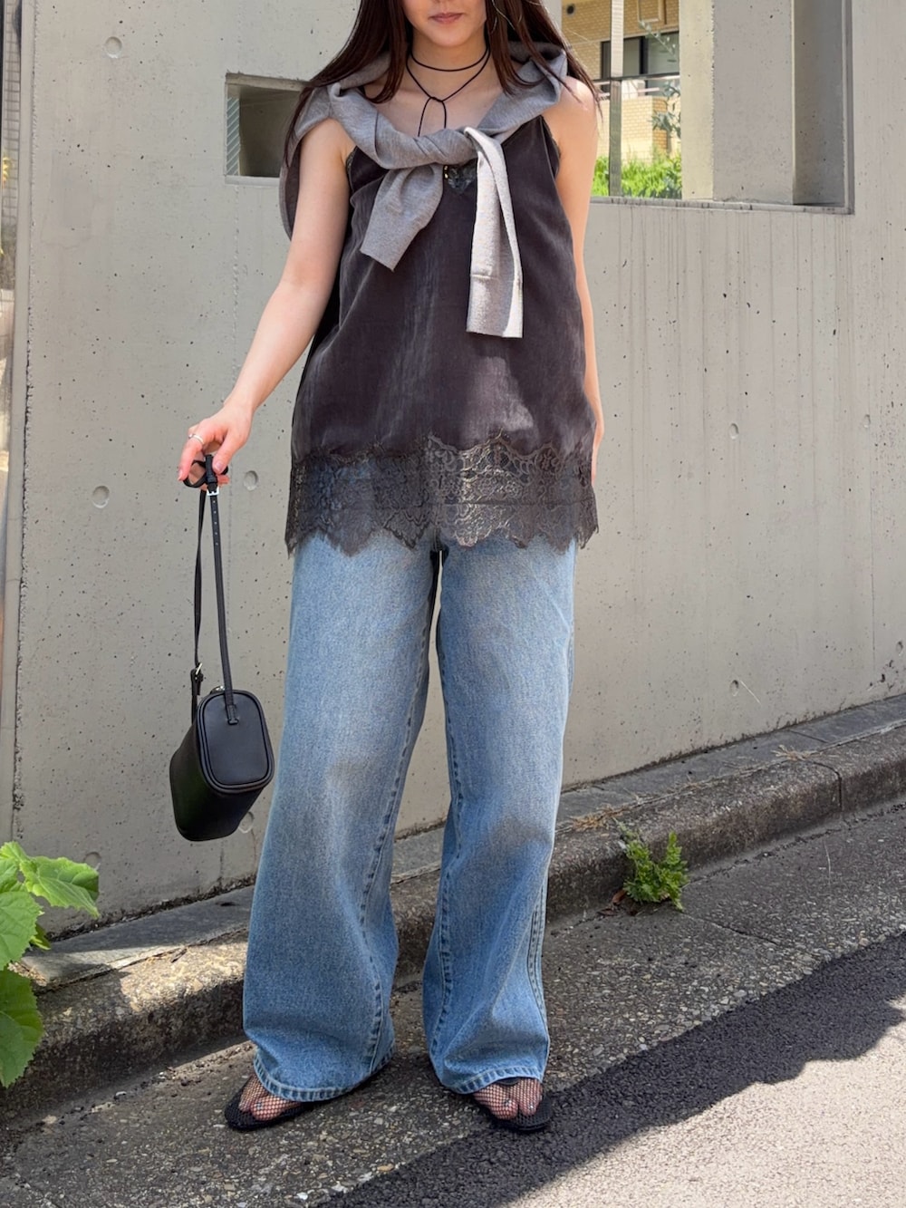 グレー系のキャミソール、ブルー系のデニムパンツ、グレー系のカーディガン/ボレロを着用したレディースの夏コーディネートの2枚目の写真