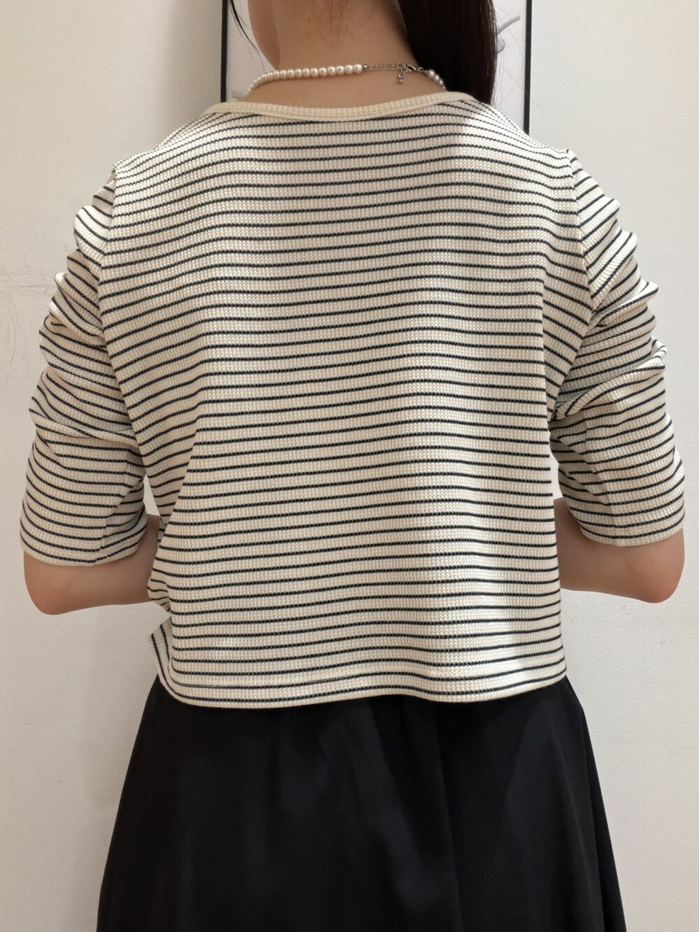 ホワイト系のTシャツ/カットソー、ブラック系のスカート、ベージュ系のショルダーバッグを着用したレディースの夏コーディネートの7枚目の写真