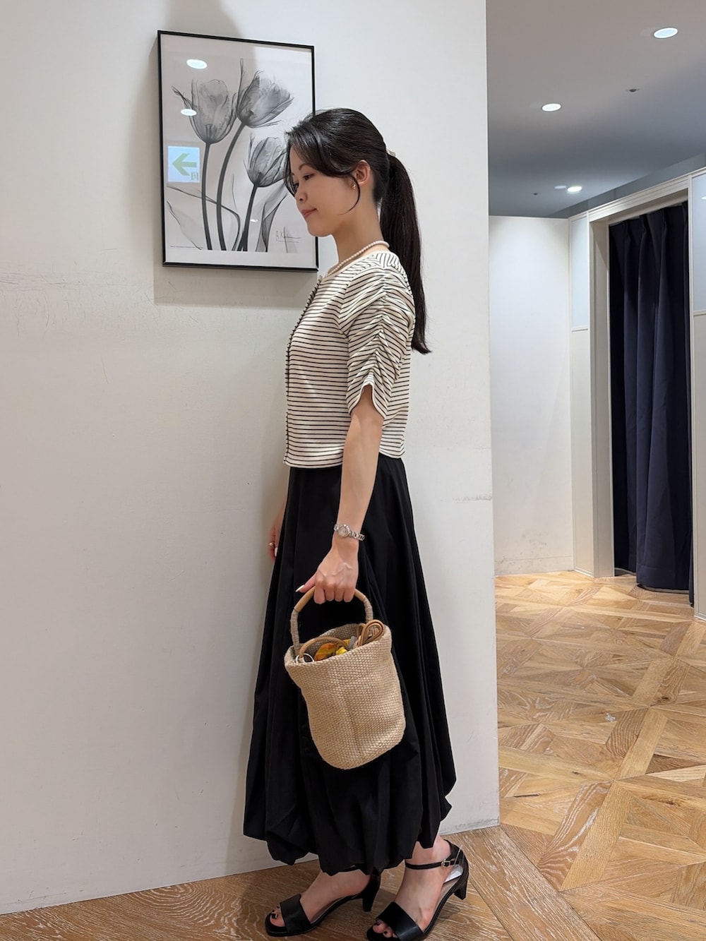 ホワイト系のTシャツ/カットソー、ブラック系のスカート、ベージュ系のショルダーバッグを着用したレディースの夏コーディネートの4枚目の写真