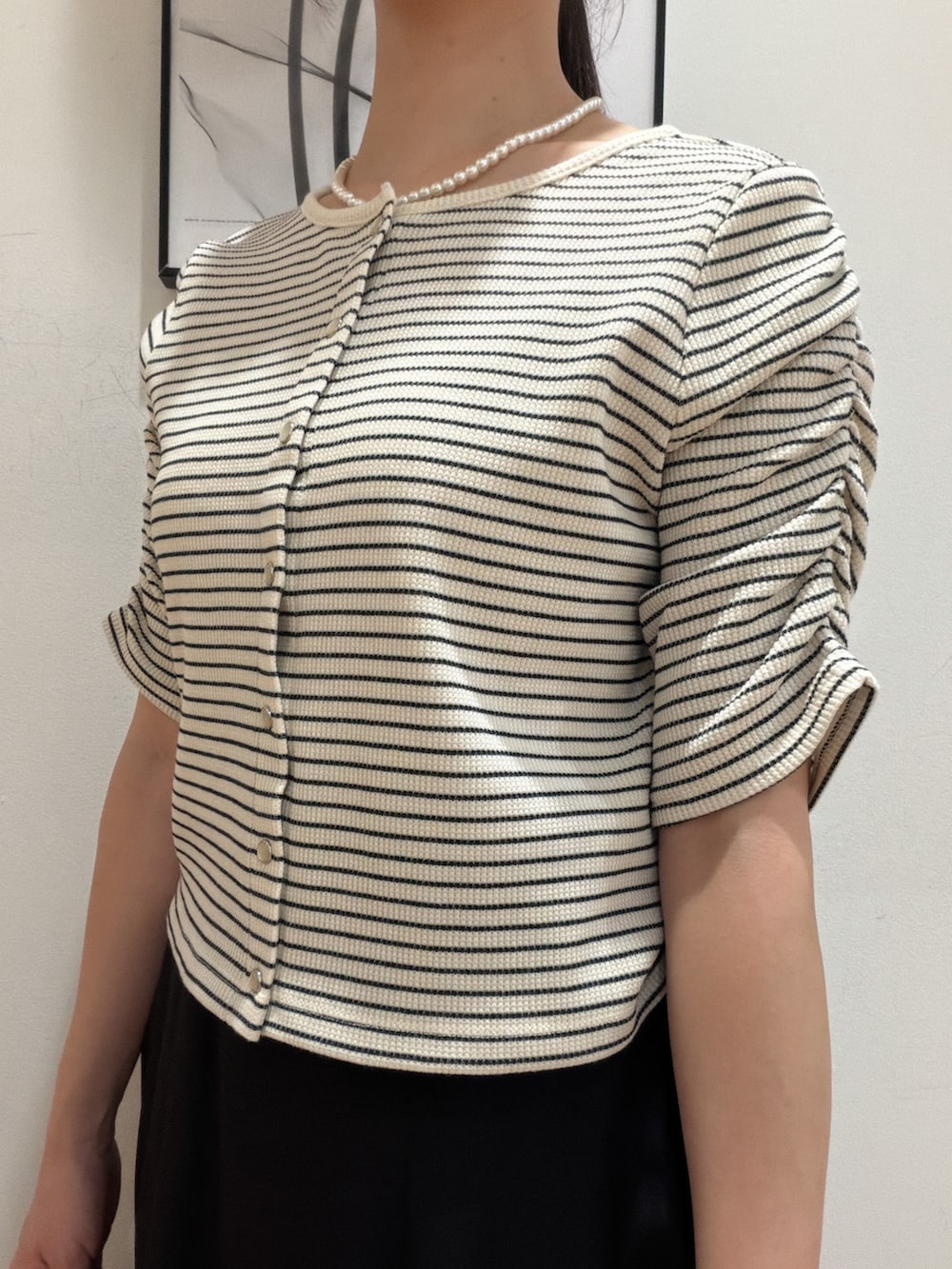 ホワイト系のTシャツ/カットソー、ブラック系のスカート、ベージュ系のショルダーバッグを着用したレディースの夏コーディネートの6枚目の写真
