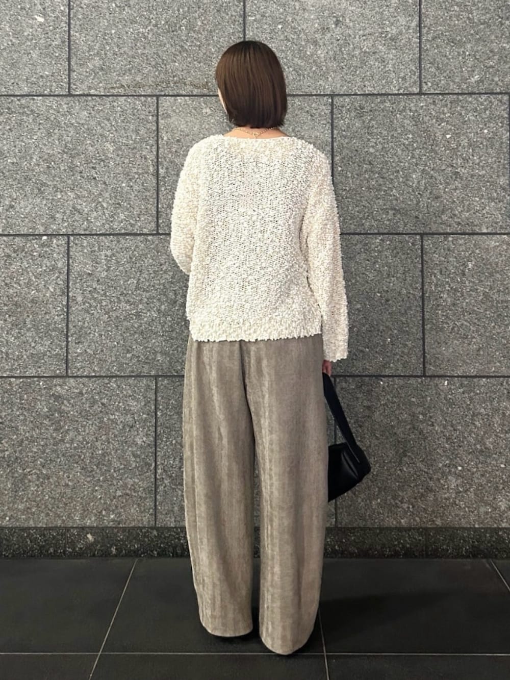 ホワイト系のニット/セーター、ベージュ系のその他パンツ、ブラック系のトートバッグを着用したレディースの秋コーディネートの3枚目の写真