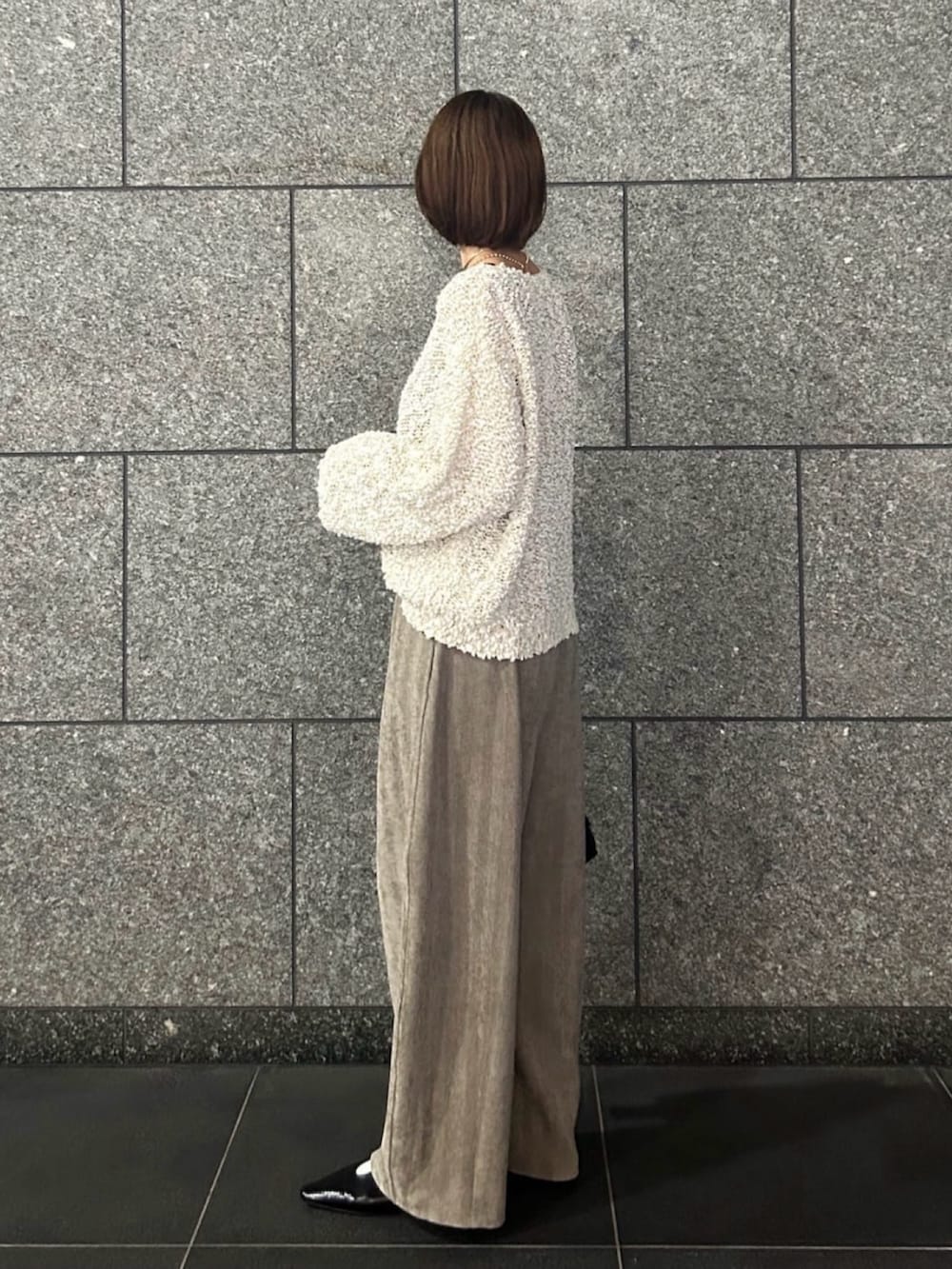 ホワイト系のニット/セーター、ベージュ系のその他パンツ、ブラック系のトートバッグを着用したレディースの秋コーディネートの2枚目の写真