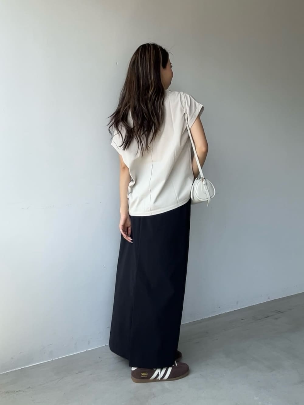 ベージュ系のTシャツ/カットソー、ホワイト系のショルダーバッグを着用したレディースの春コーディネートの3枚目の写真