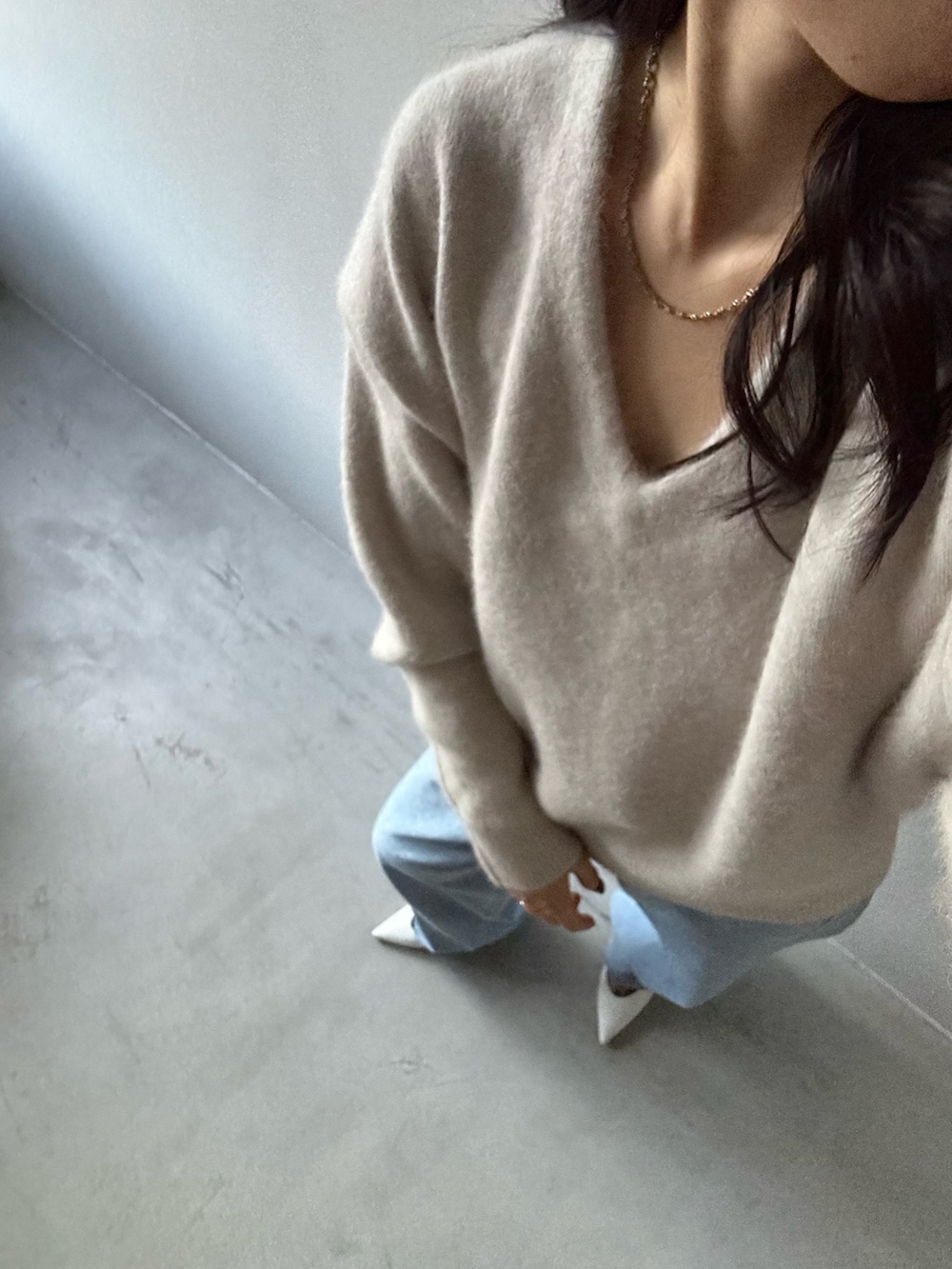 グレー系のニット/セーター、ブルー系のデニムパンツを着用したレディースの冬コーディネートの5枚目の写真