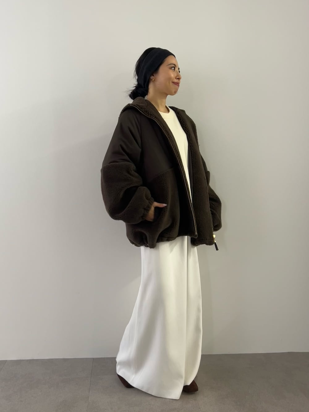 ホワイト系のニット/セーター、ホワイト系のスカート、ブラウン系のブルゾンを着用したレディースの冬コーディネートの2枚目の写真