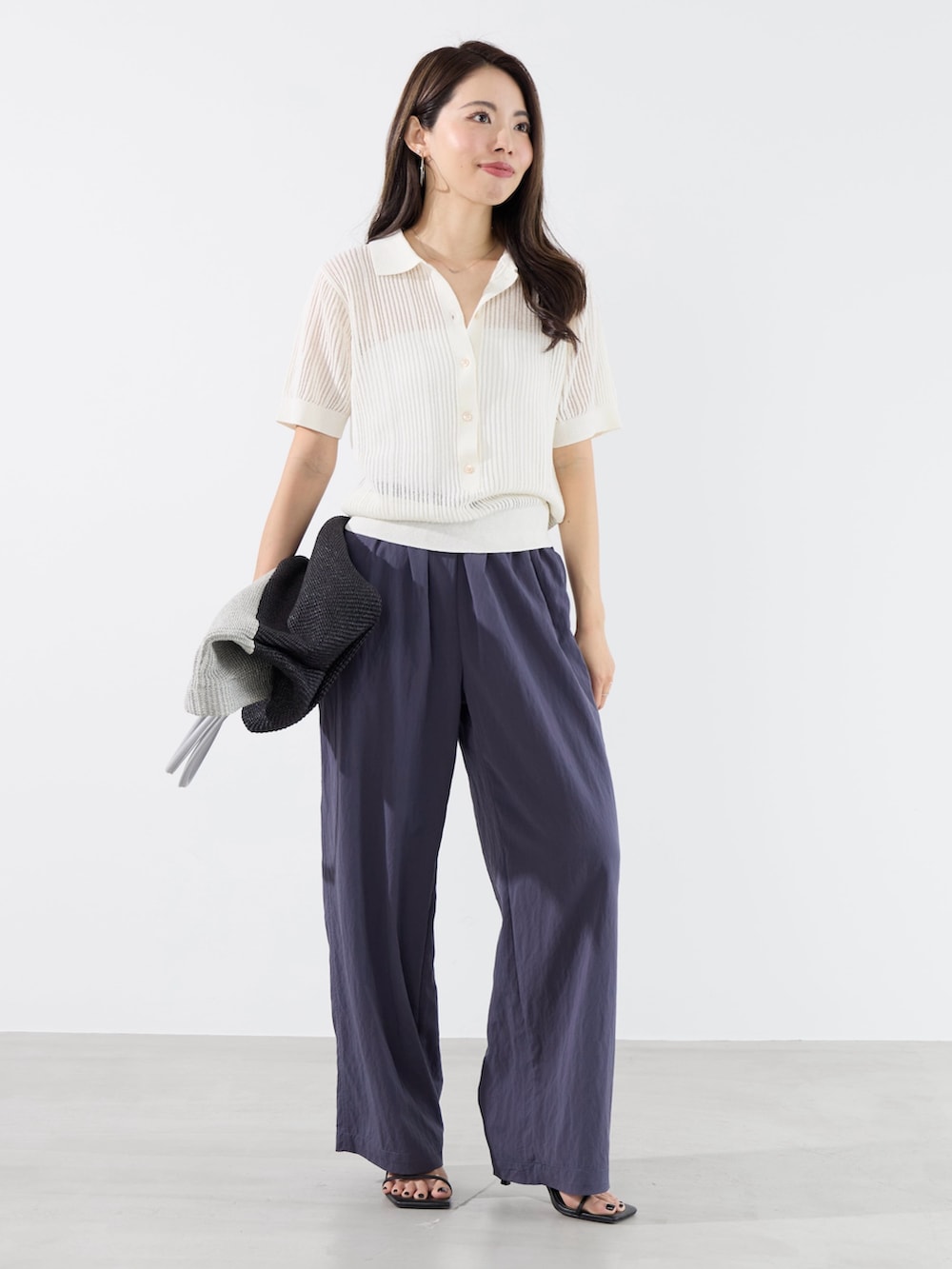 ブルー系のその他パンツ、ホワイト系のニット/セーター、グレー系のトートバッグを着用したレディースの夏コーディネートの2枚目の写真