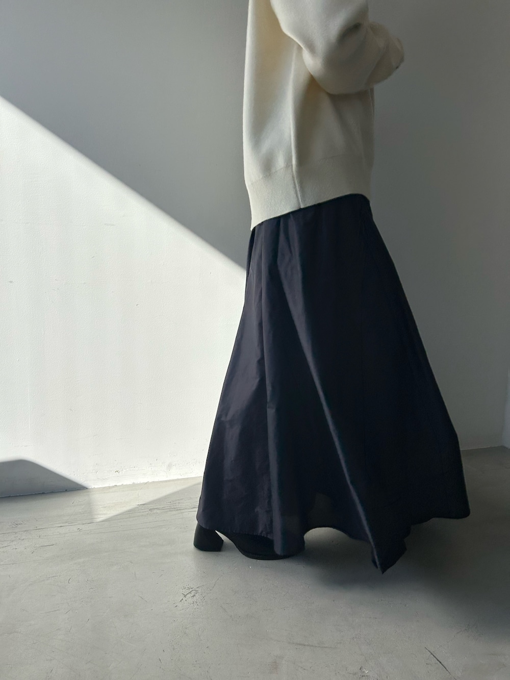 ブルー系のスカート、ホワイト系のニット/セーターを着用したレディースの冬コーディネートの4枚目の写真