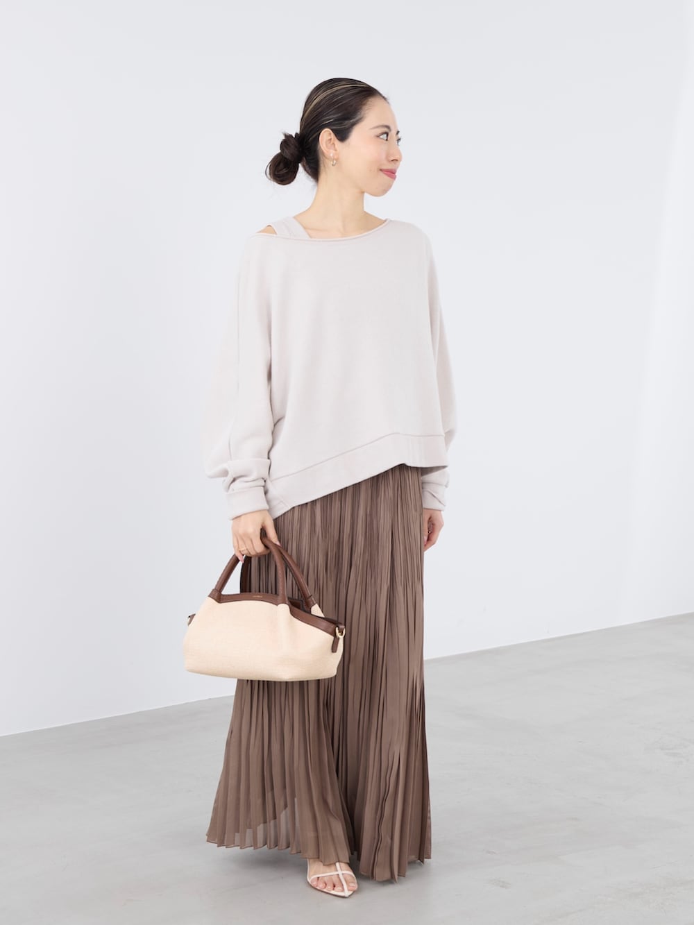 ベージュ系のスウェット、ベージュ系のタンクトップ、ベージュ系のスカートを着用したレディースの春コーディネートの2枚目の写真