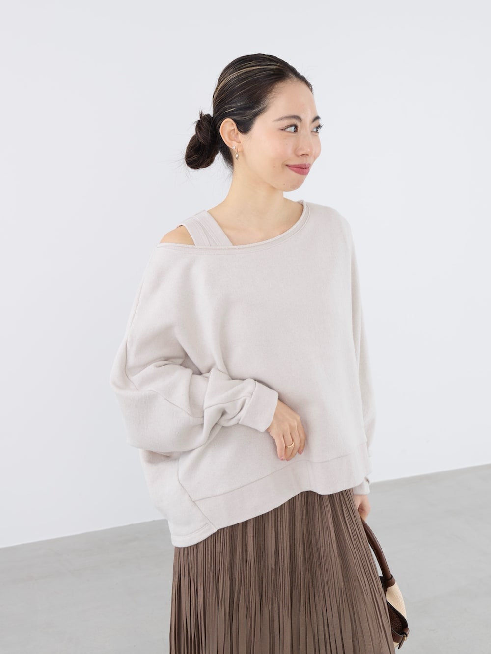 ベージュ系のスウェット、ベージュ系のタンクトップ、ベージュ系のスカートを着用したレディースの春コーディネートの3枚目の写真