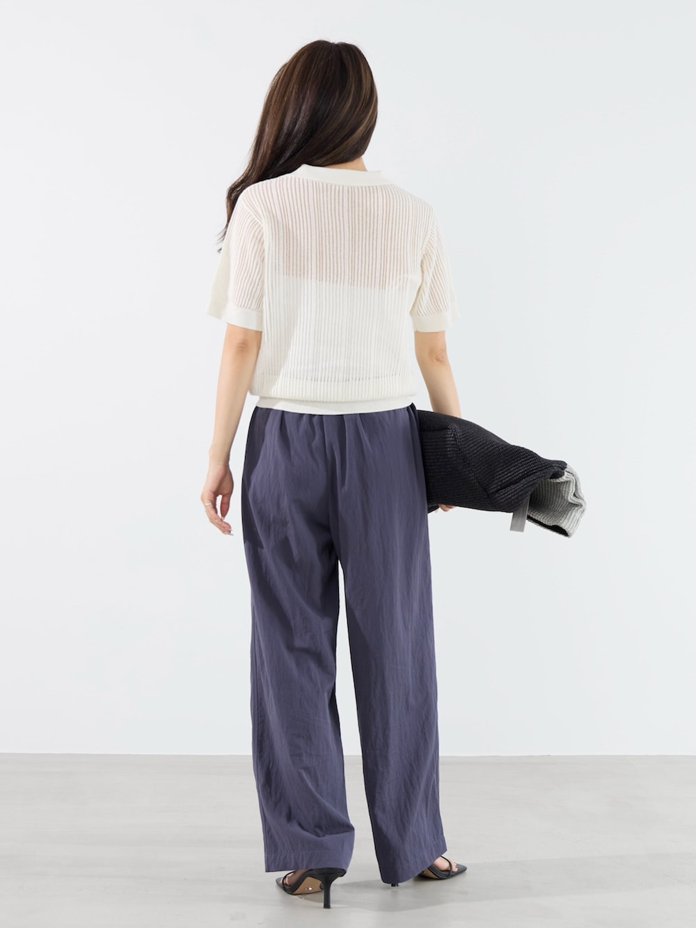 ブルー系のその他パンツ、ホワイト系のニット/セーター、グレー系のトートバッグを着用したレディースの夏コーディネートの3枚目の写真