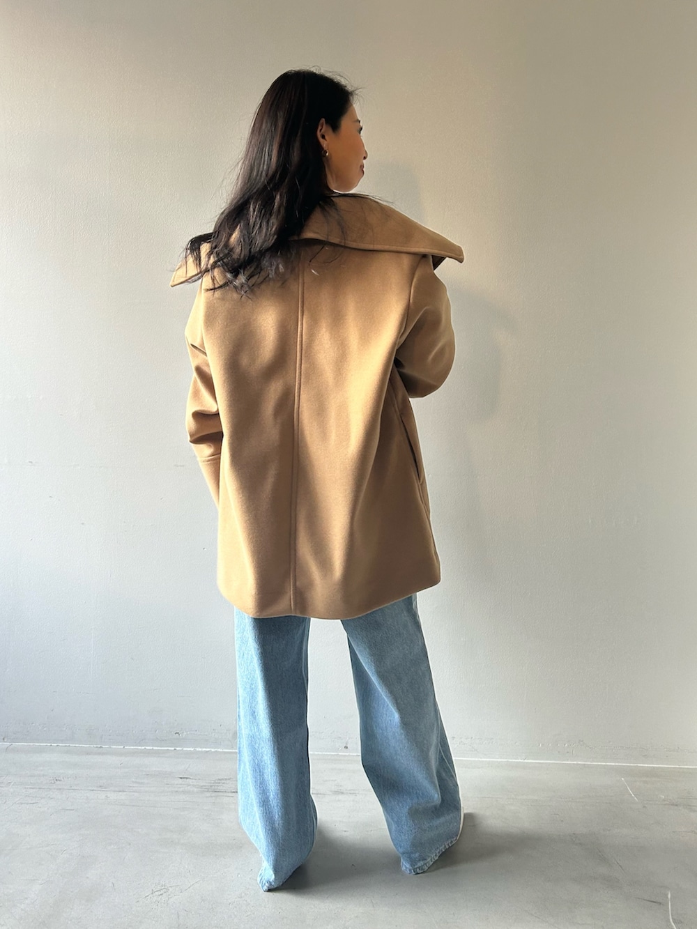 イエロー系のその他アウター、グレー系のニット/セーター、ブルー系のデニムパンツを着用したレディースの冬コーディネートの3枚目の写真