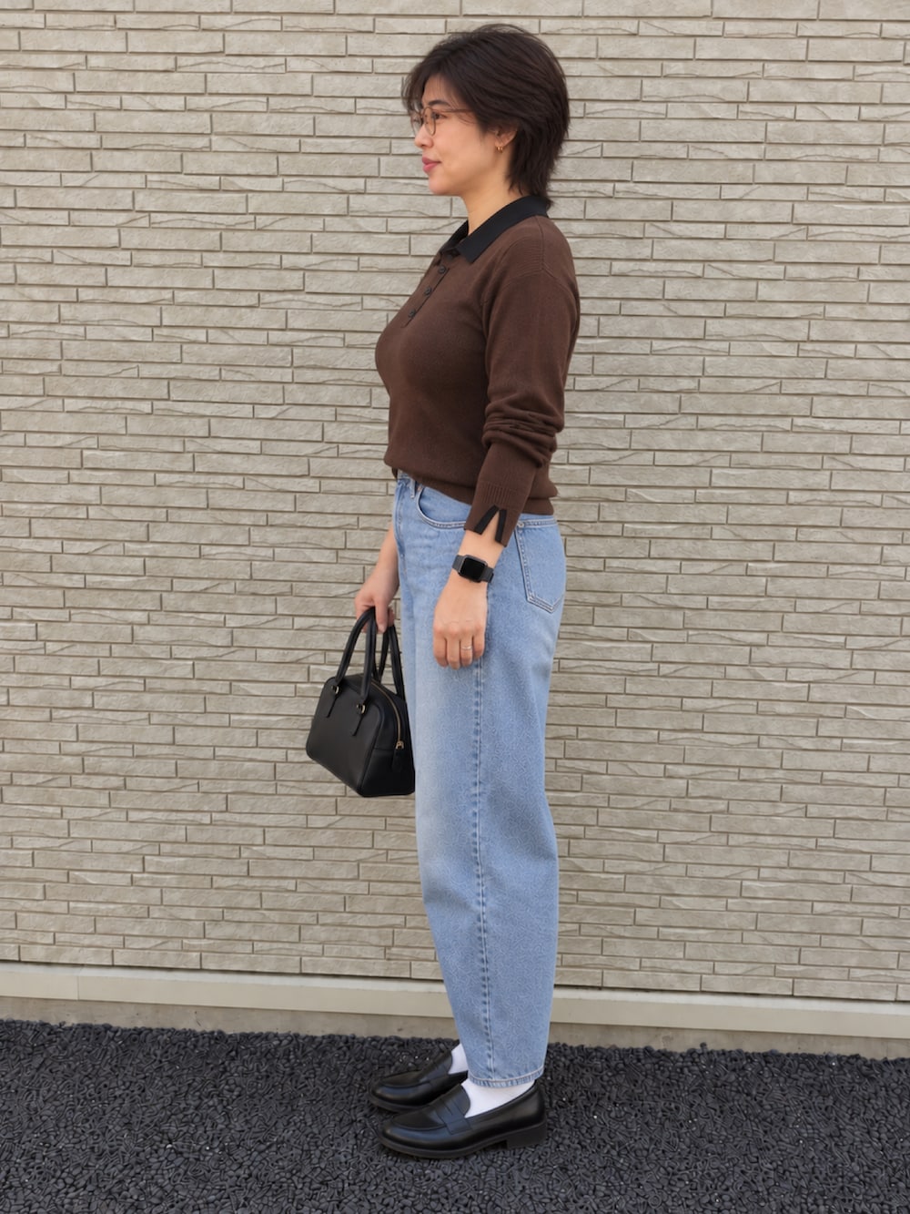 ブラウン系のニット/セーター、ブルー系のデニムパンツ、ブラック系のローファーを着用したレディースの秋コーディネートの2枚目の写真
