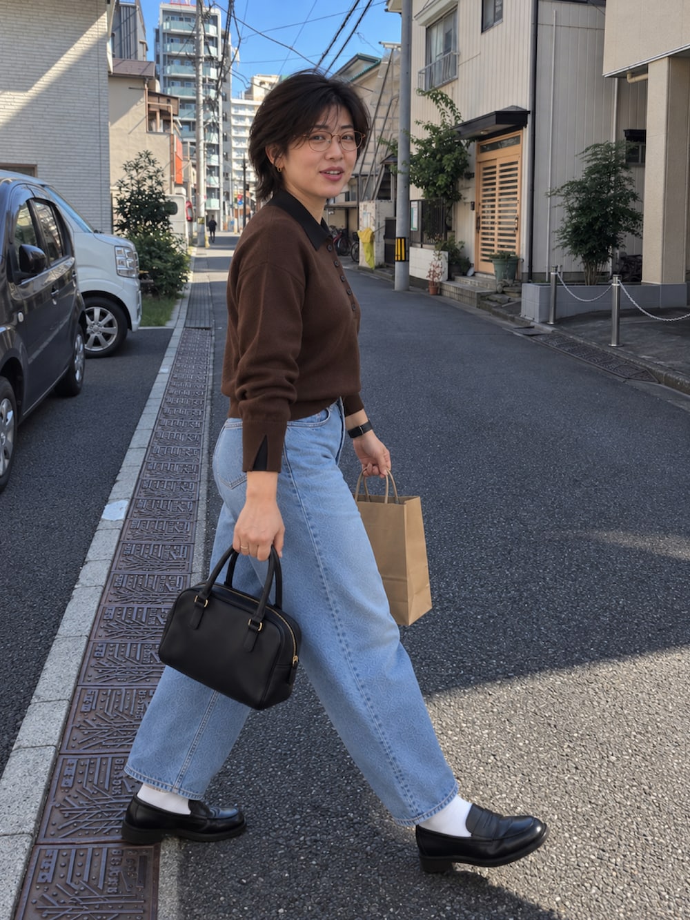 ブラウン系のニット/セーター、ブルー系のデニムパンツ、ブラック系のローファーを着用したレディースの秋コーディネートの5枚目の写真