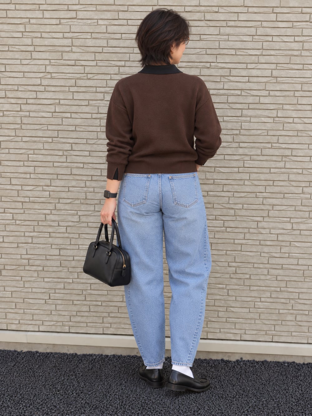 ブラウン系のニット/セーター、ブルー系のデニムパンツ、ブラック系のローファーを着用したレディースの秋コーディネートの3枚目の写真