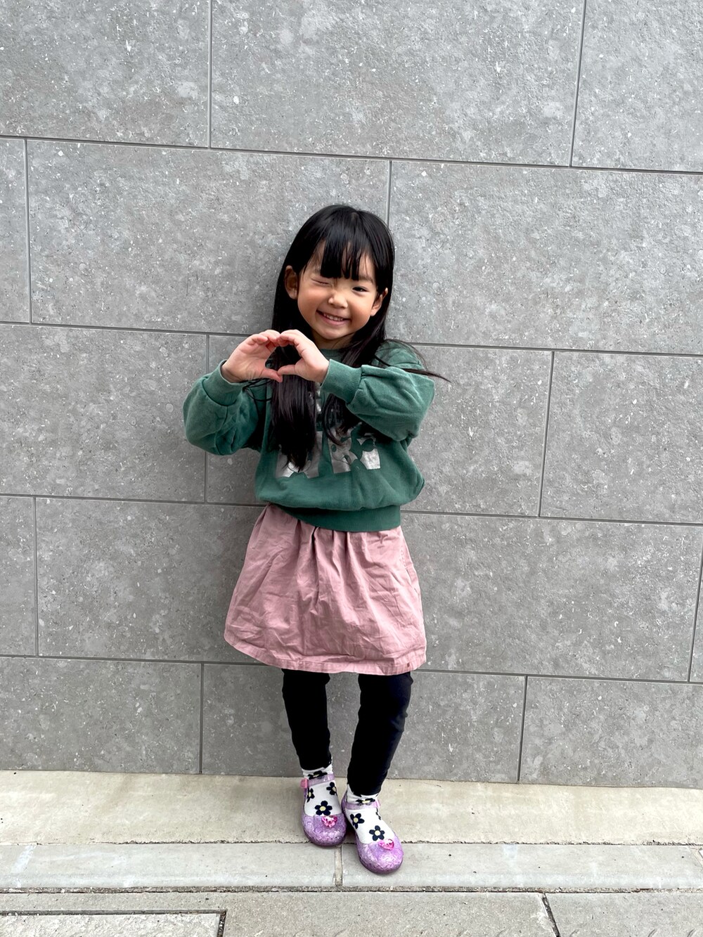 グリーン系のスウェット、ピンク系のスカートを着用したキッズの冬コーディネートの2枚目の写真