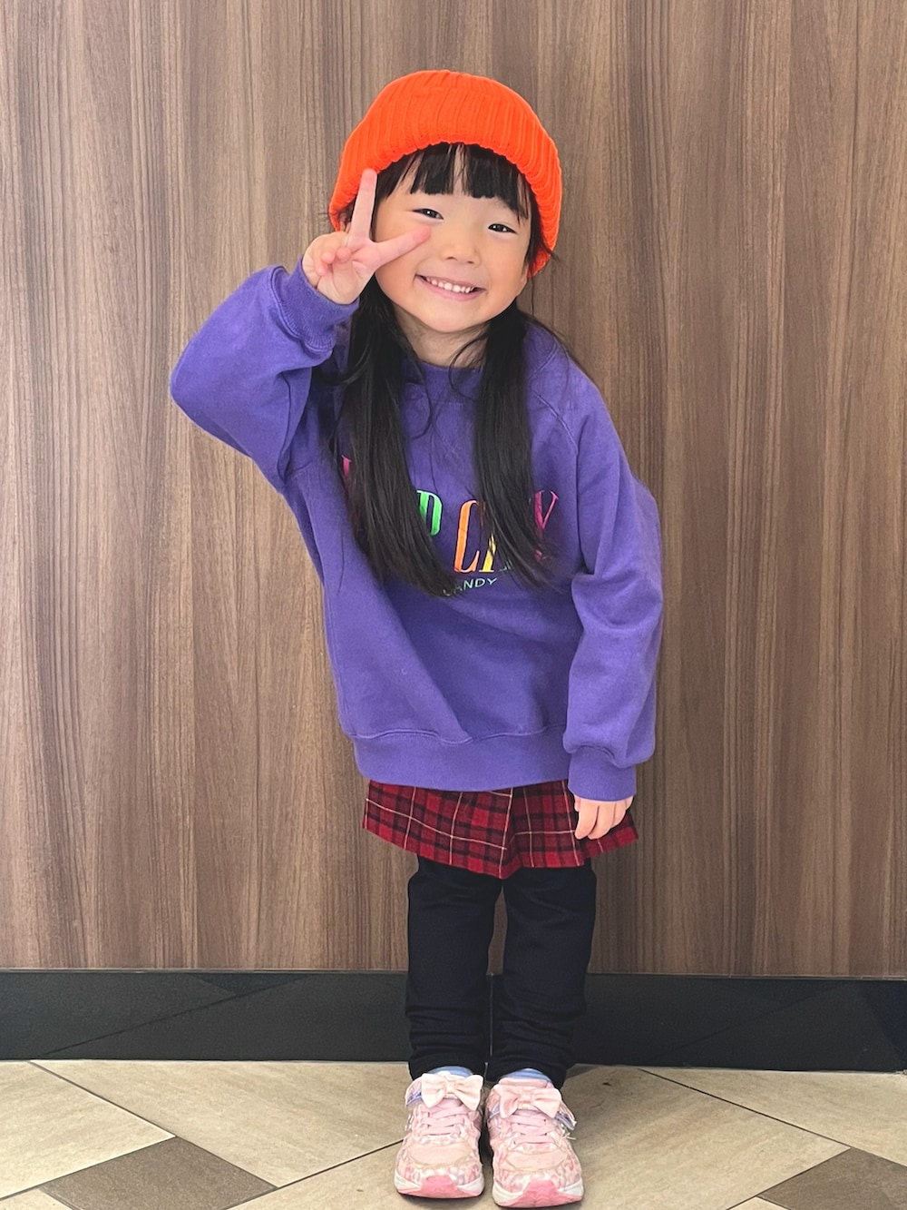 パープル系のスウェット、レッド系のスカート、オレンジ系のニットキャップ/ビーニーを着用したキッズの冬コーディネートの2枚目の写真