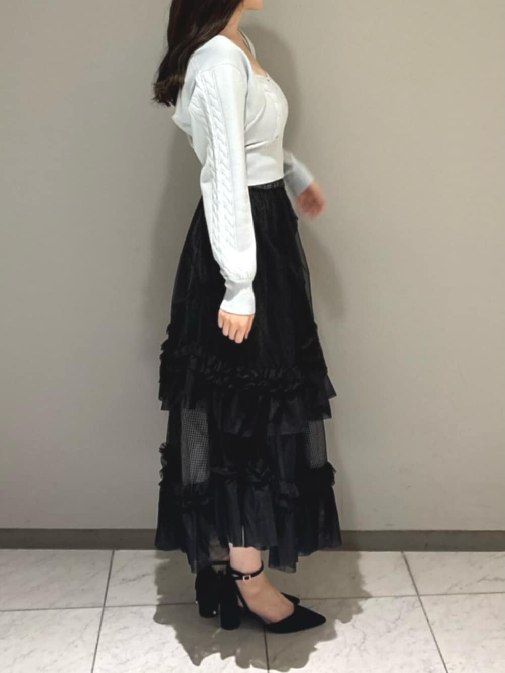 ブラック系のパンプス、ブルー系のカーディガン/ボレロ、ブルー系のキャミソールを着用したレディースの秋コーディネートの2枚目の写真