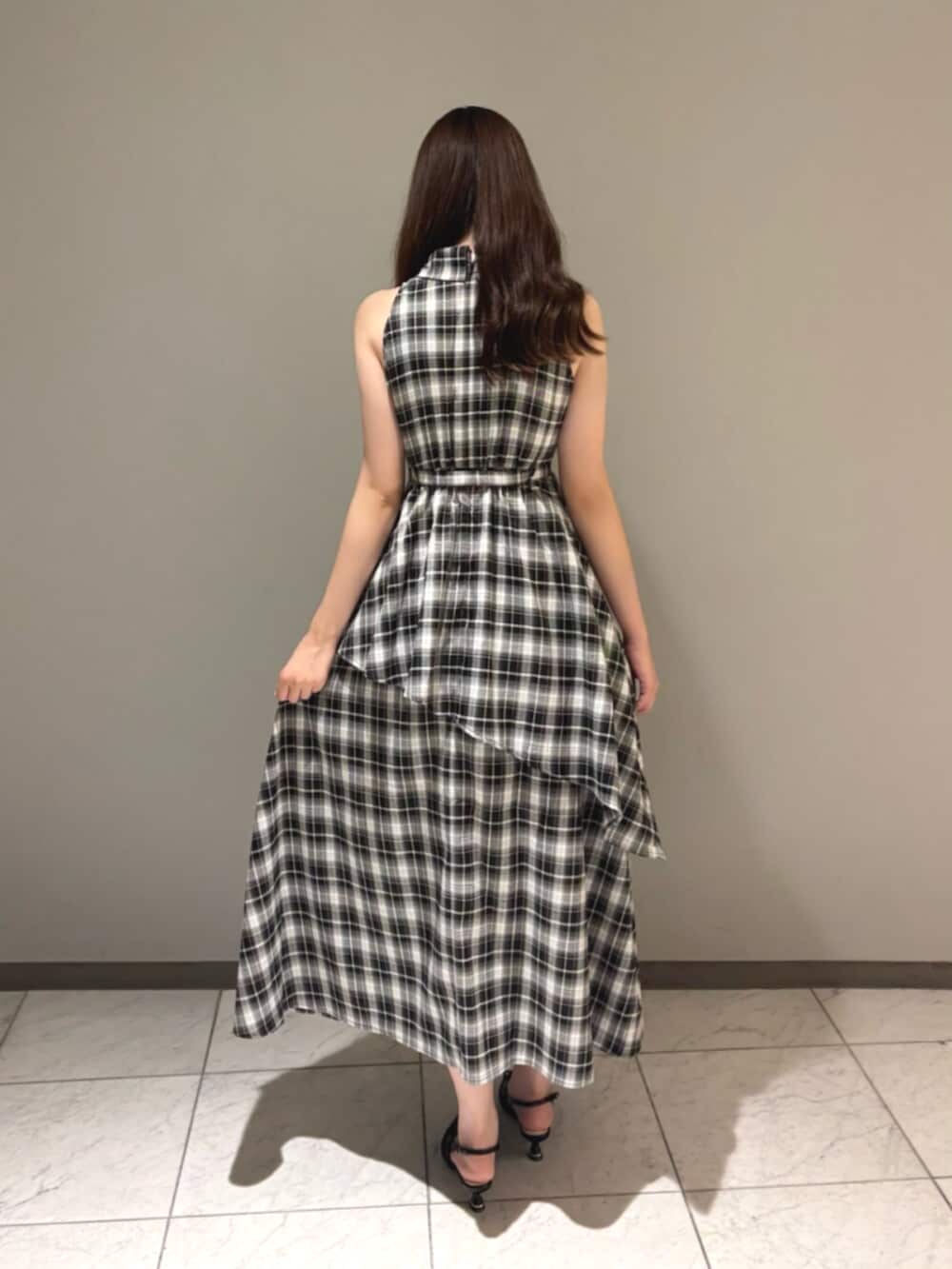 ブラック系のワンピース、ブラック系のパンプスを着用したレディースの夏コーディネートの3枚目の写真