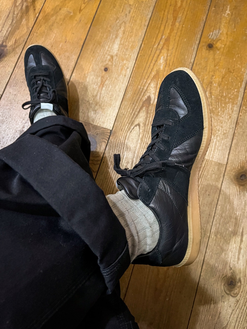 ブラック系のスウェット、ホワイト系のミリタリージャケット、ブラック系のパンツを着用したメンズの春コーディネートの3枚目の写真