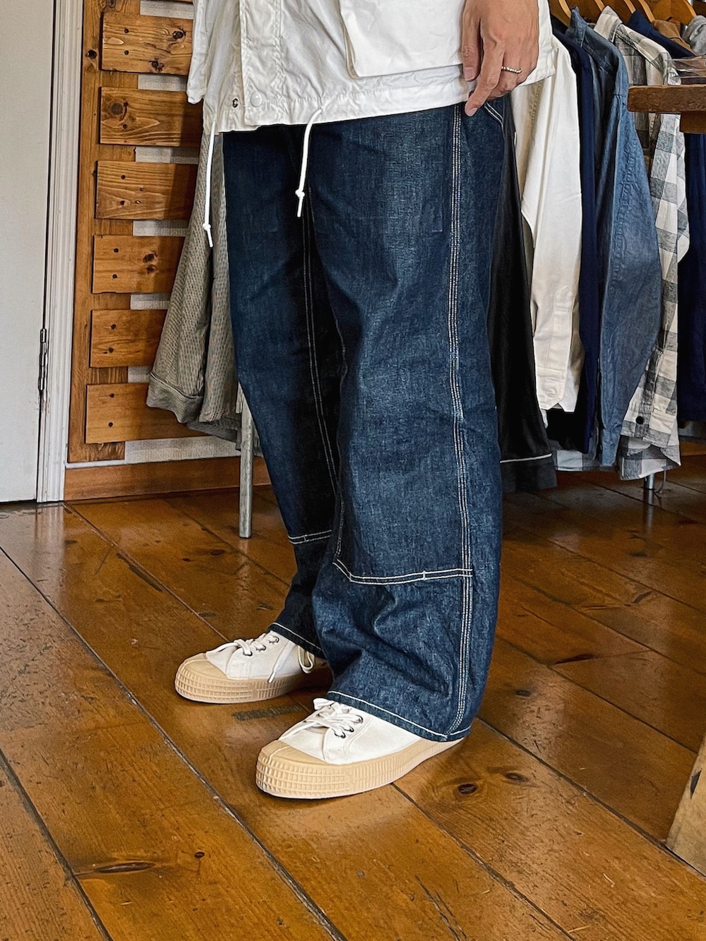 ホワイト系のTシャツ/カットソー、ホワイト系のミリタリージャケット、ブルー系のデニムパンツを着用したメンズの春コーディネートの3枚目の写真