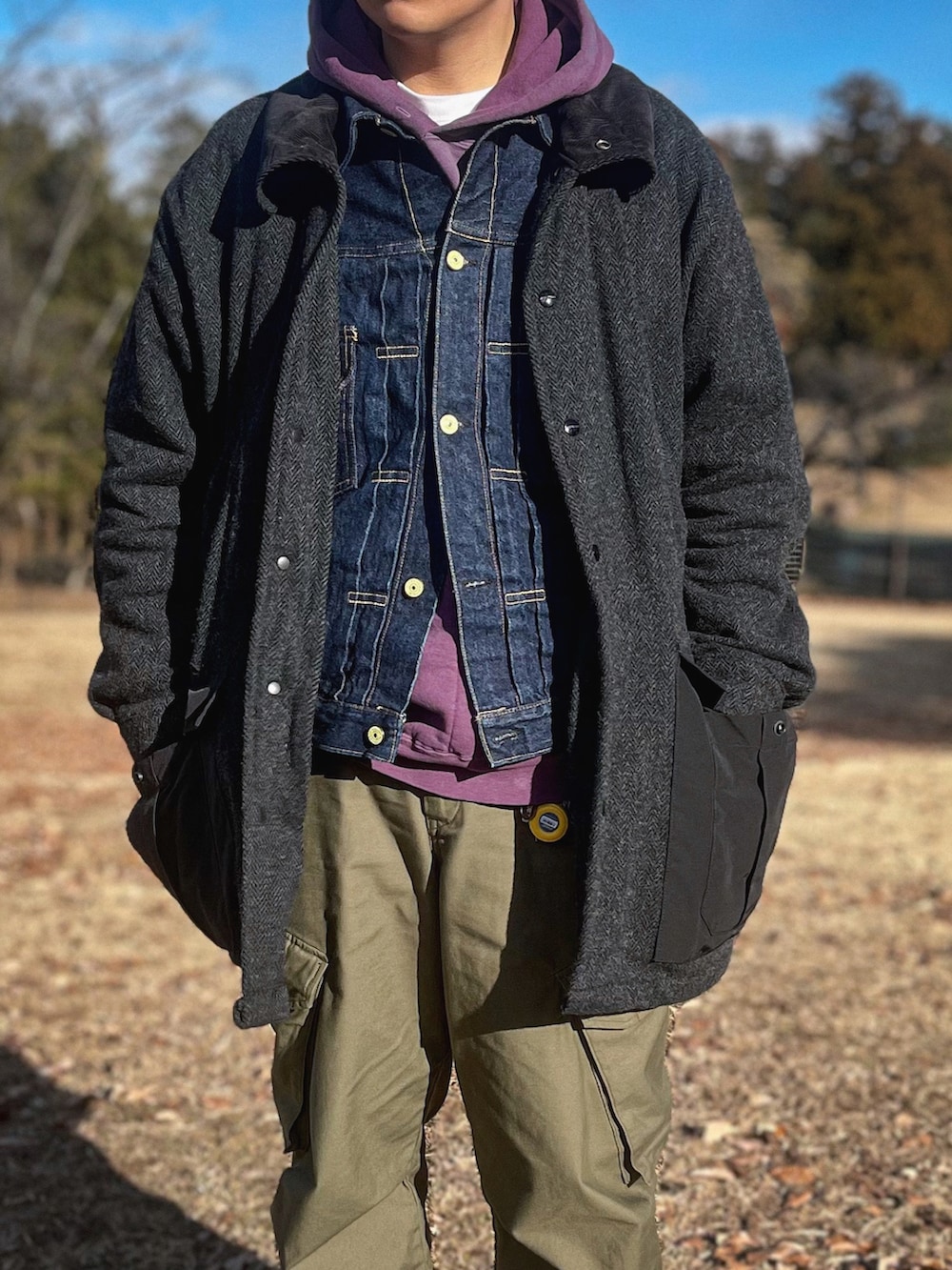 パープル系のパーカー、ブルー系のデニムジャケット、グレー系のジャケット/アウターを着用したメンズの冬コーディネートの2枚目の写真