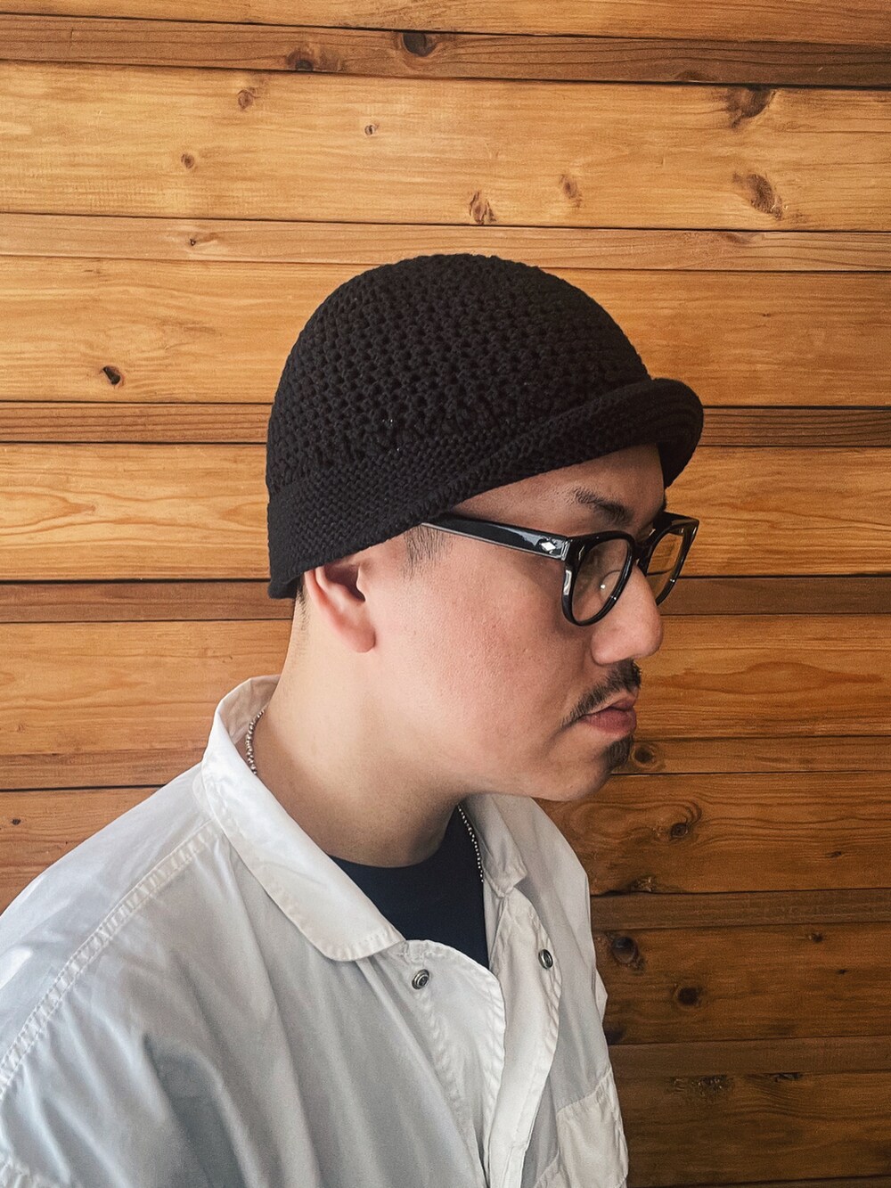 ホワイト系のミリタリージャケット、ブルー系のデニムパンツ、ブラック系のハットを着用したメンズの春コーディネートの4枚目の写真