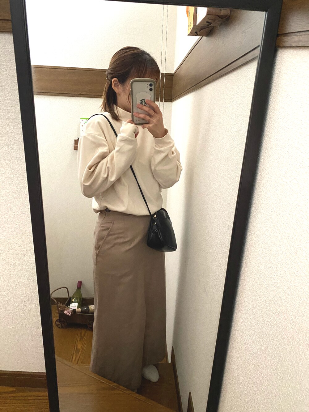 ホワイト系のTシャツ/カットソー、ベージュ系のスカート、ブラック系のショルダーバッグを着用したレディースの秋コーディネートの2枚目の写真