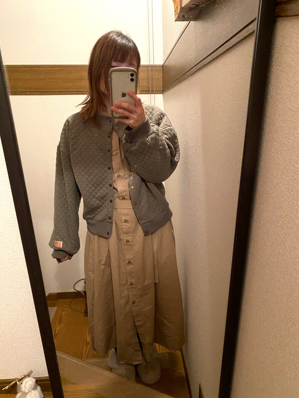 ベージュ系のシャツワンピース、グリーン系のカーディガン/ボレロを着用したレディースの冬コーディネートの2枚目の写真