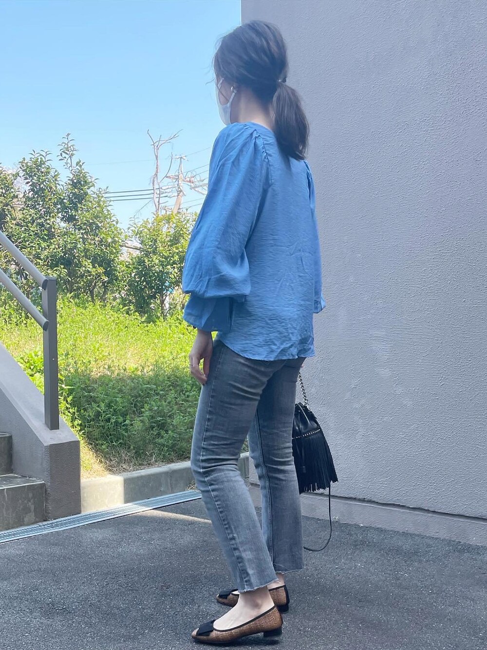 ブルー系のシャツ/ブラウス、グレー系のデニムパンツ、ブラック系のショルダーバッグを着用したレディースの春コーディネートの3枚目の写真