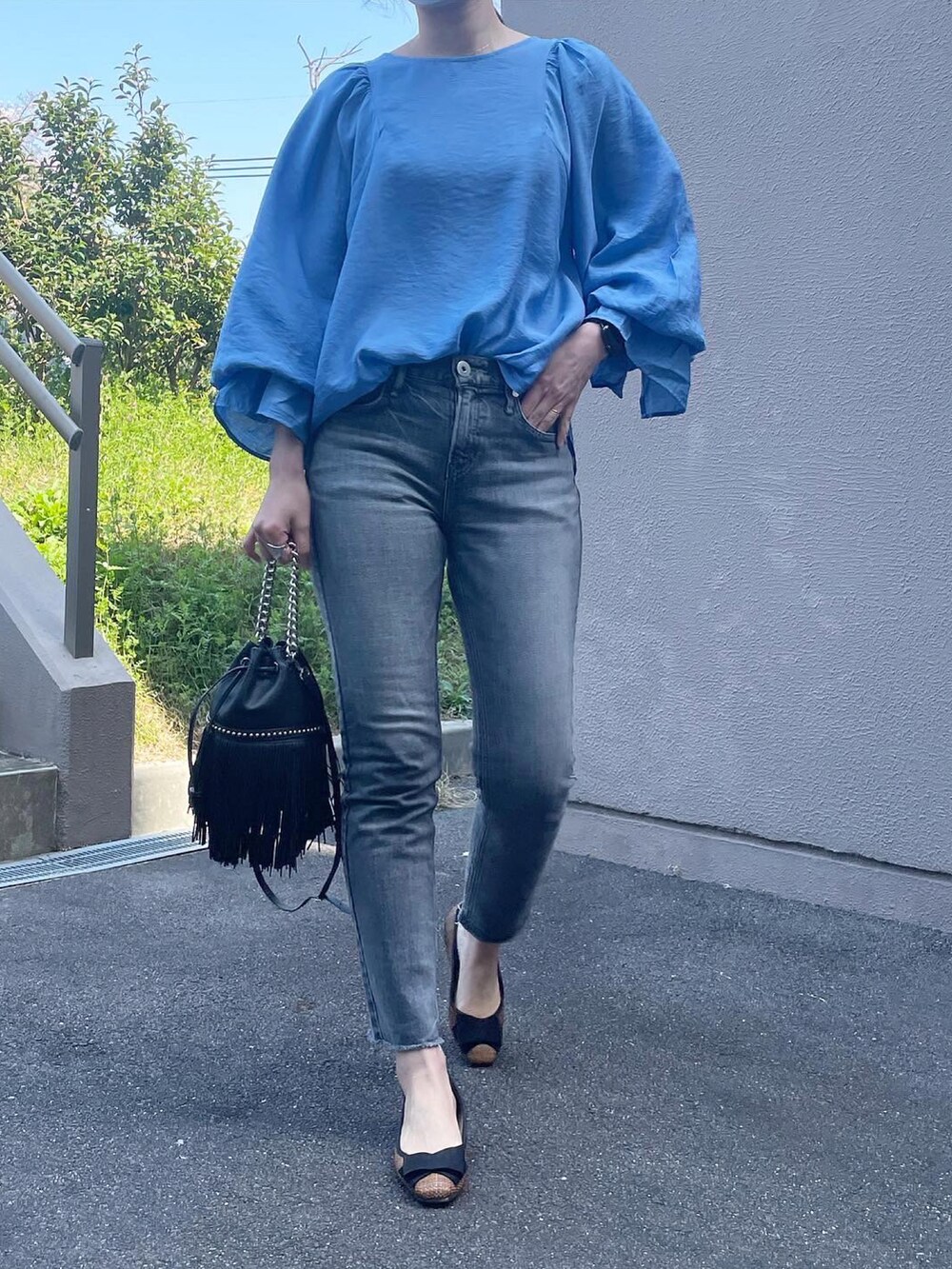 ブルー系のシャツ/ブラウス、グレー系のデニムパンツ、ブラック系のショルダーバッグを着用したレディースの春コーディネートの2枚目の写真
