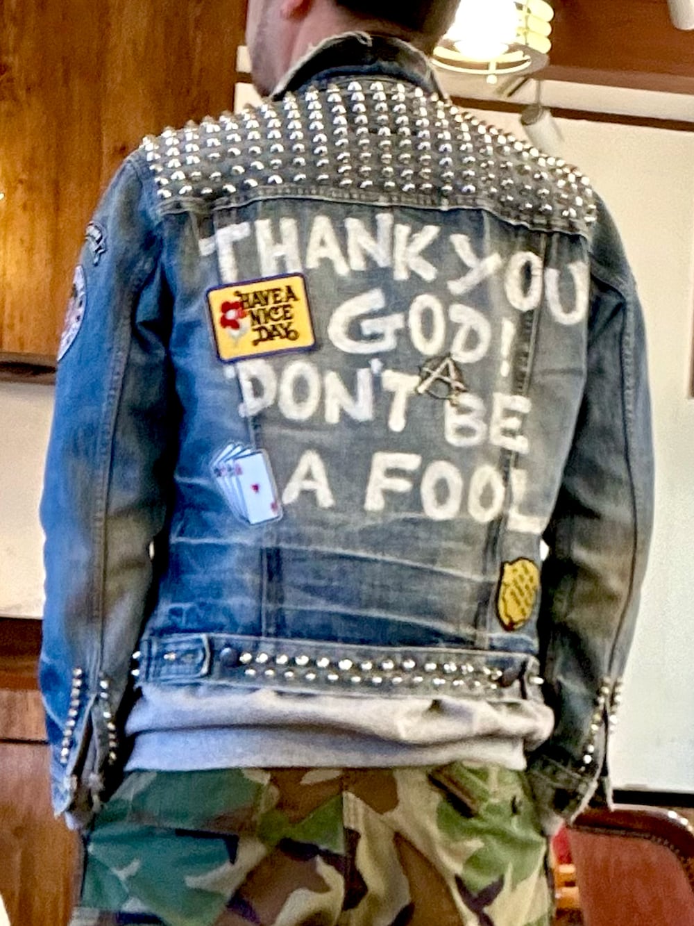 ホワイト系のスニーカー、グリーン系のカーゴパンツ、ブルー系のデニムジャケットを着用したメンズの春コーディネートの2枚目の写真