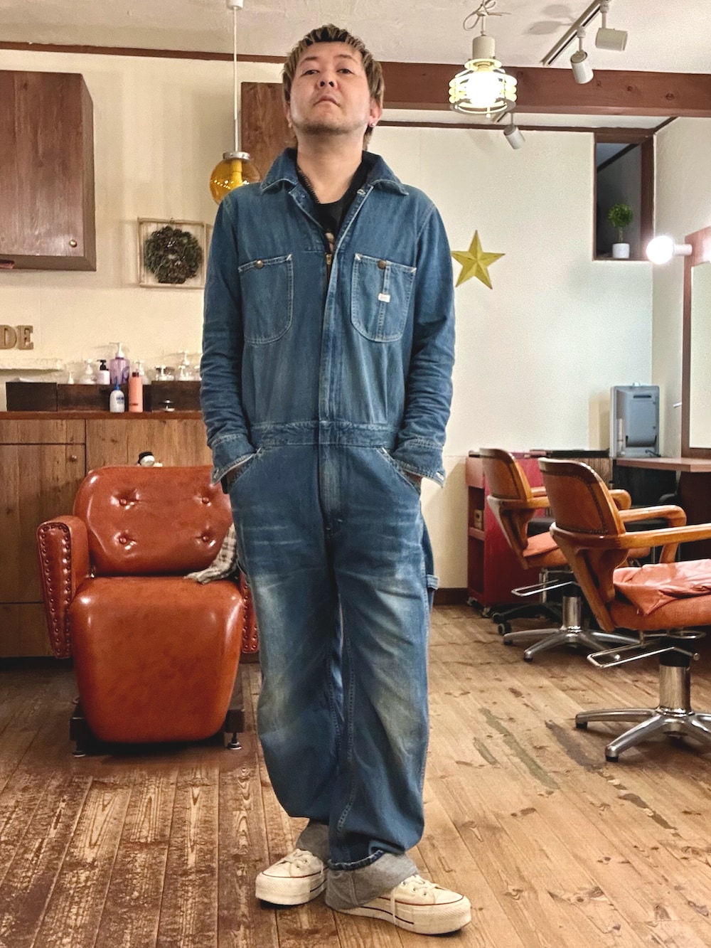 ホワイト系のスニーカー、グリーン系のミリタリージャケット、ブルー系のつなぎ/オールインワンを着用したメンズの冬コーディネートの2枚目の写真