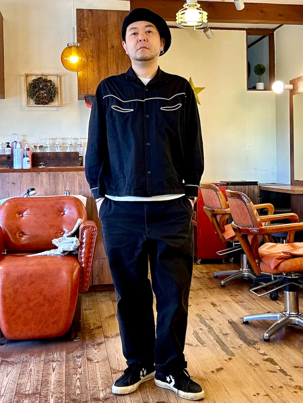 グリーン系のミリタリージャケット、ブラック系のシャツ/ブラウス、ホワイト系のTシャツ/カットソーを着用したメンズの春コーディネートの2枚目の写真
