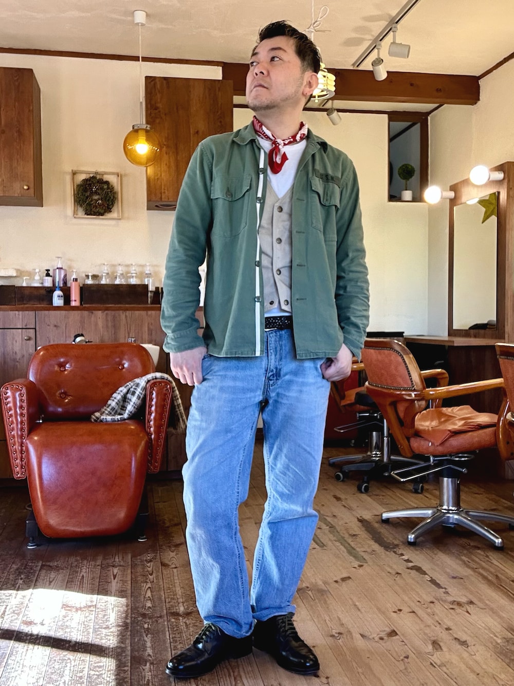 ブルー系のデニムパンツ、ブラック系のドレスシューズ、レッド系のブルゾンを着用したメンズの冬コーディネートの2枚目の写真