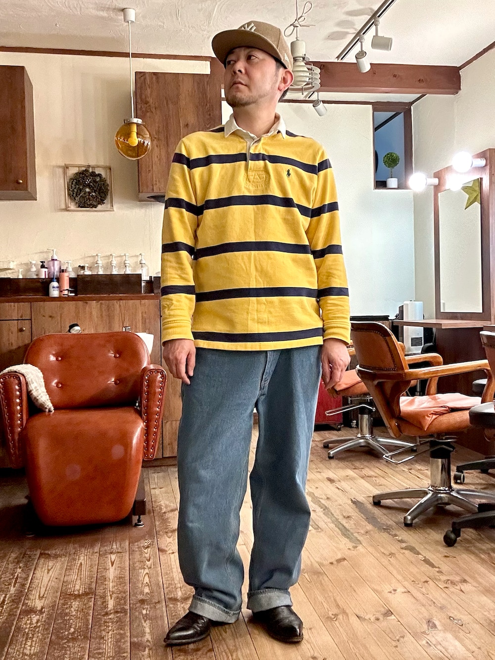 ブラウン系のジャケット/アウター、イエロー系のポロシャツ、ブルー系のデニムパンツを着用したメンズの冬コーディネートの2枚目の写真