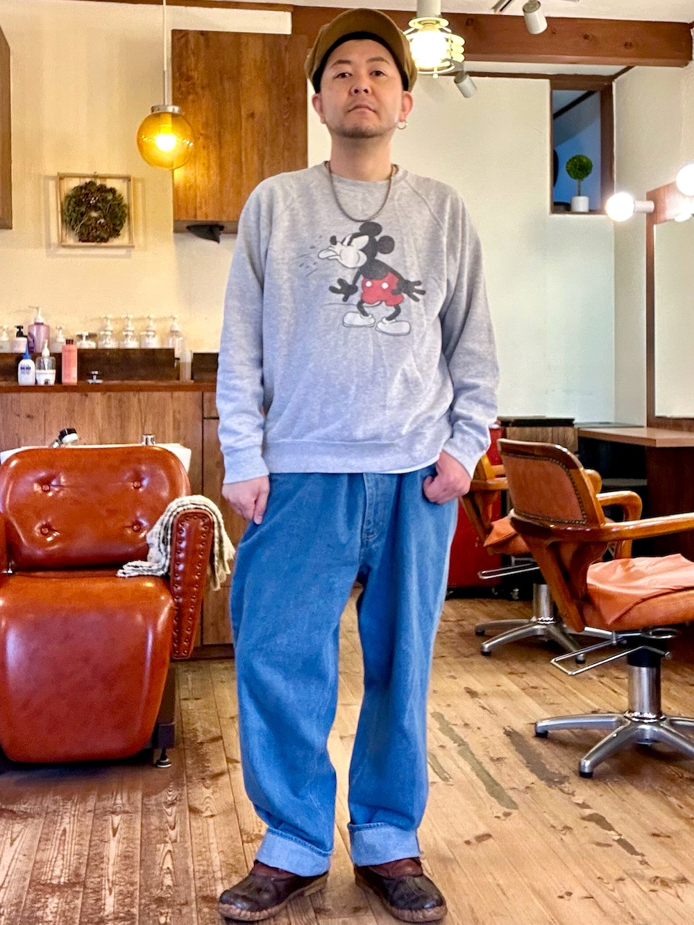 ピンク系のカバーオール、グレー系のスウェット、ブルー系のデニムパンツを着用したメンズの春コーディネートの2枚目の写真