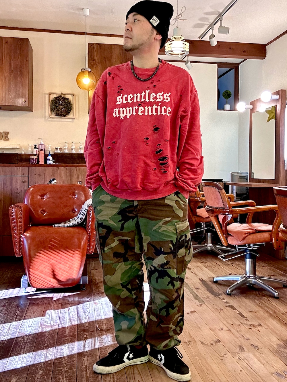 レッド系のスウェット、ブラック系のライダースジャケット、グリーン系のカーゴパンツを着用したメンズの冬コーディネートの2枚目の写真