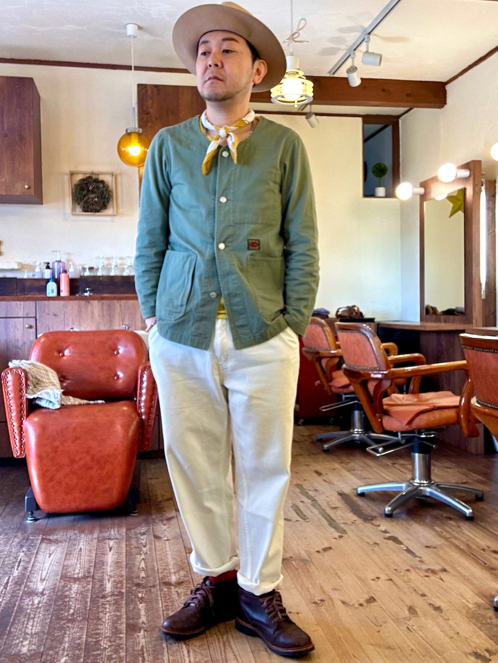 グリーン系のジャケット/アウター、ベージュ系のステンカラーコート、ホワイト系のデニムパンツを着用したメンズの春コーディネートの2枚目の写真