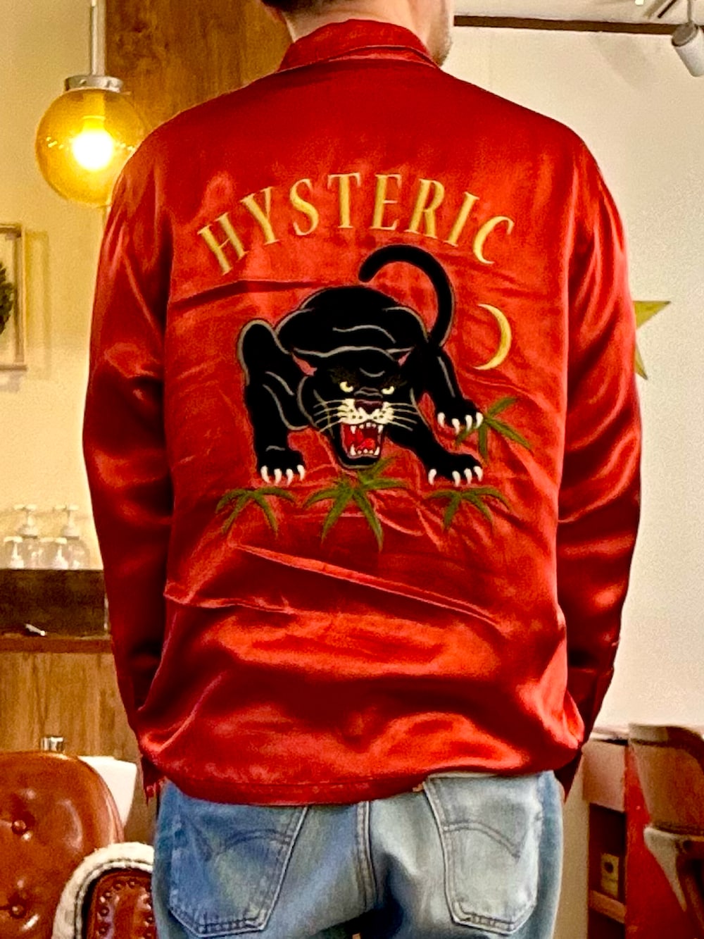 グリーン系のミリタリージャケット、ブラック系のシャツ/ブラウス、ブルー系のデニムパンツを着用したメンズの春コーディネートの3枚目の写真