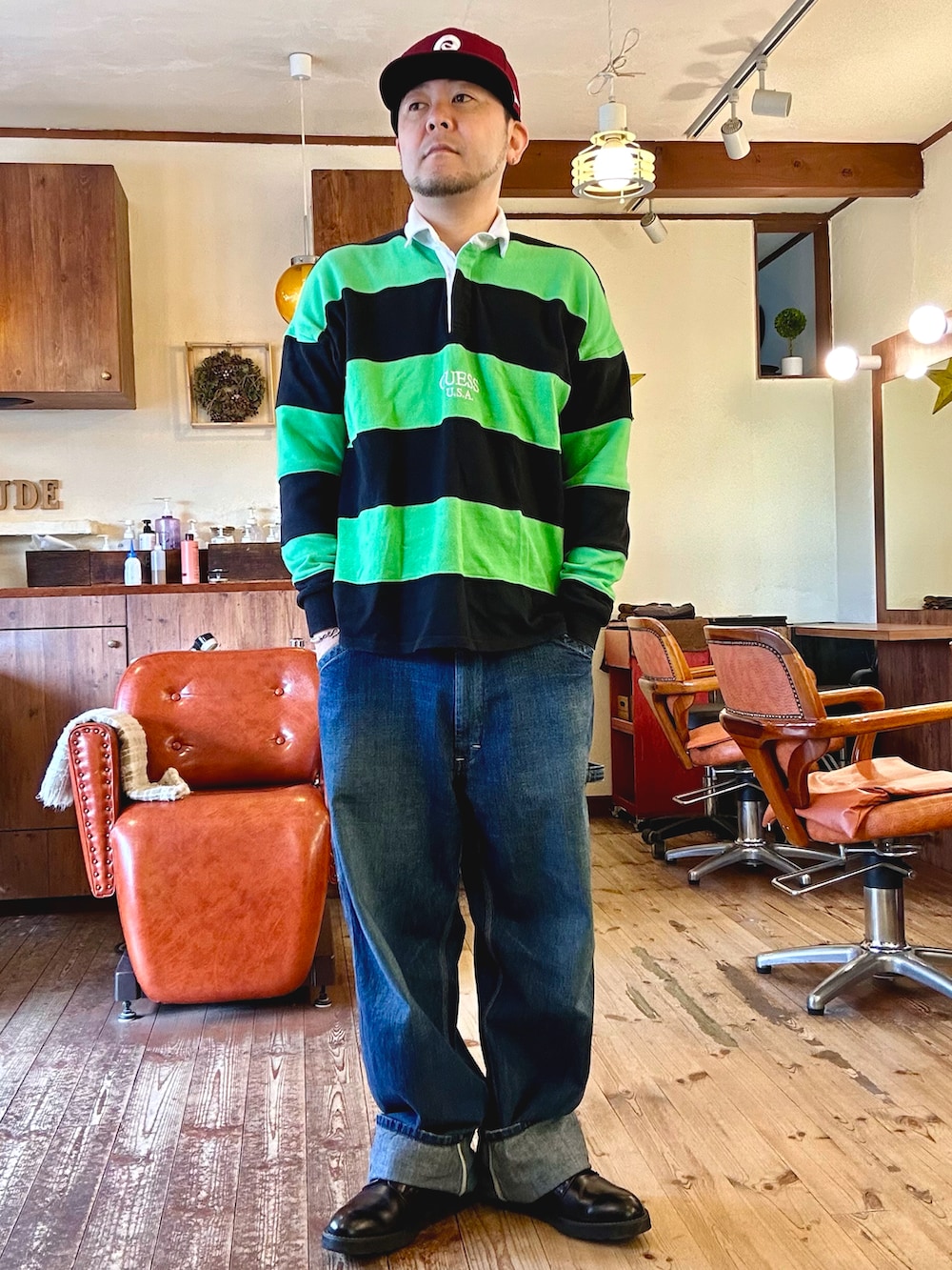 ブラック系のドレスシューズ、グリーン系のトップス、ブルー系のテーラードジャケットを着用したメンズの春コーディネートの2枚目の写真