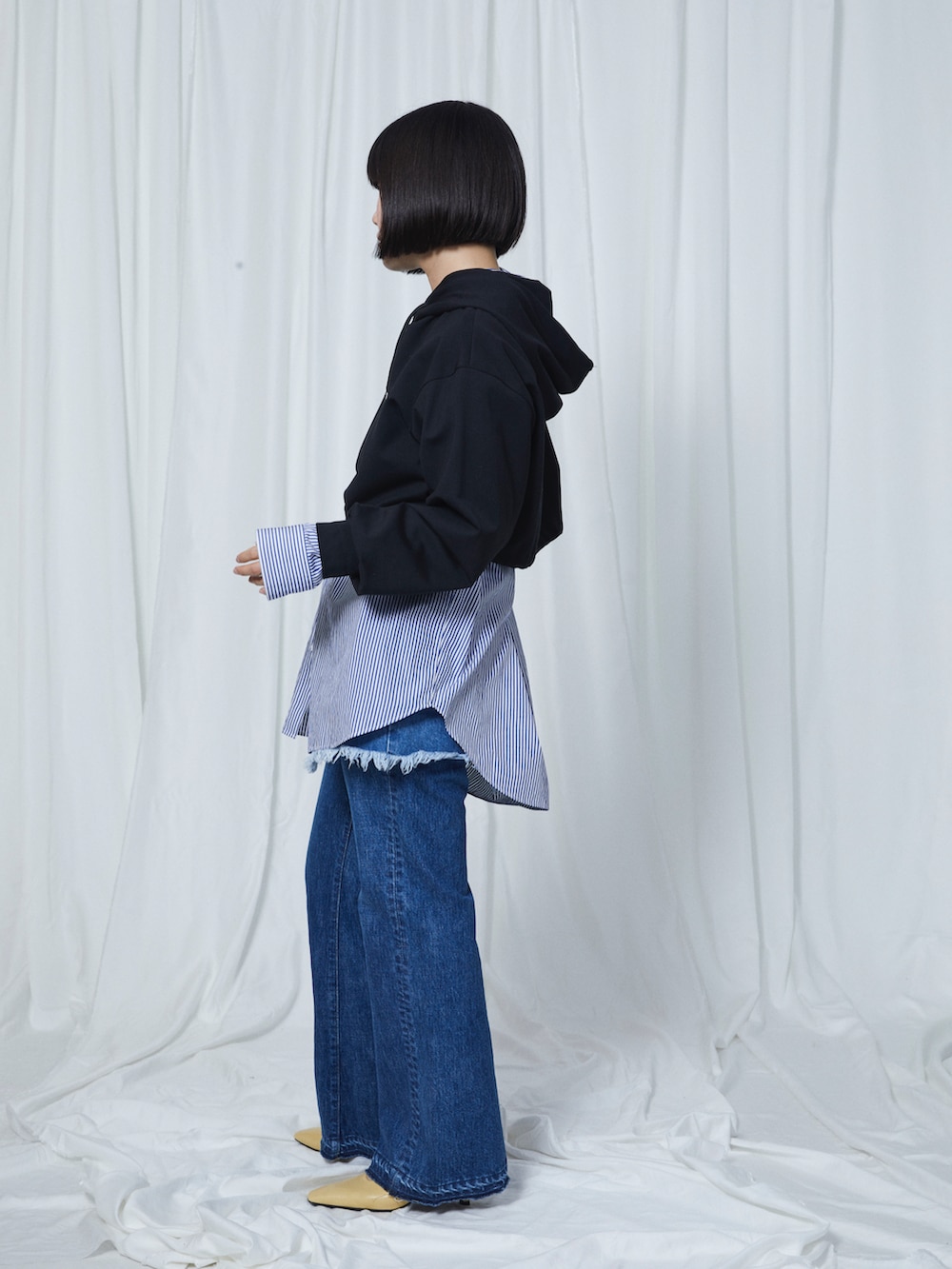 ブルー系のデニムパンツ、ブルー系のデニムスカート、ブラック系のパーカーを着用したレディースの冬コーディネートの2枚目の写真