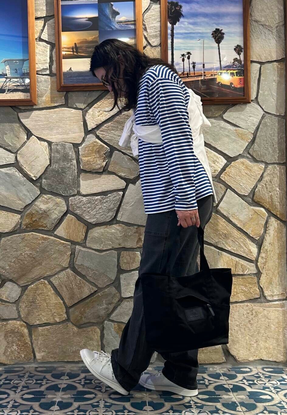 ホワイト系のスニーカー、ブルー系のTシャツ/カットソー、ブラック系のトートバッグを着用したメンズの夏コーディネートの2枚目の写真