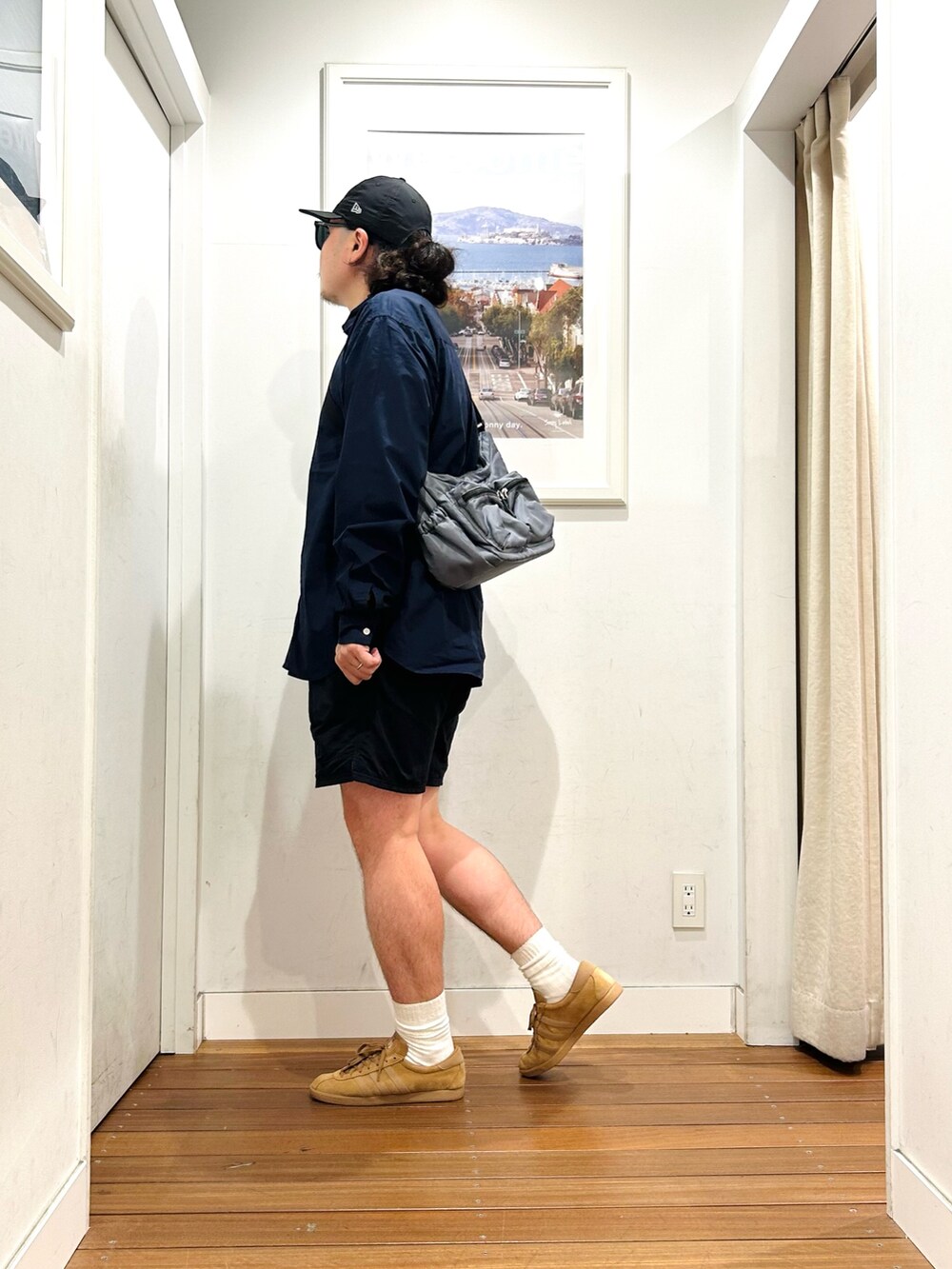 グレー系のショルダーバッグ、ブルー系のシャツ/ブラウス、ブラウン系のスニーカーを着用したメンズの秋コーディネートの3枚目の写真